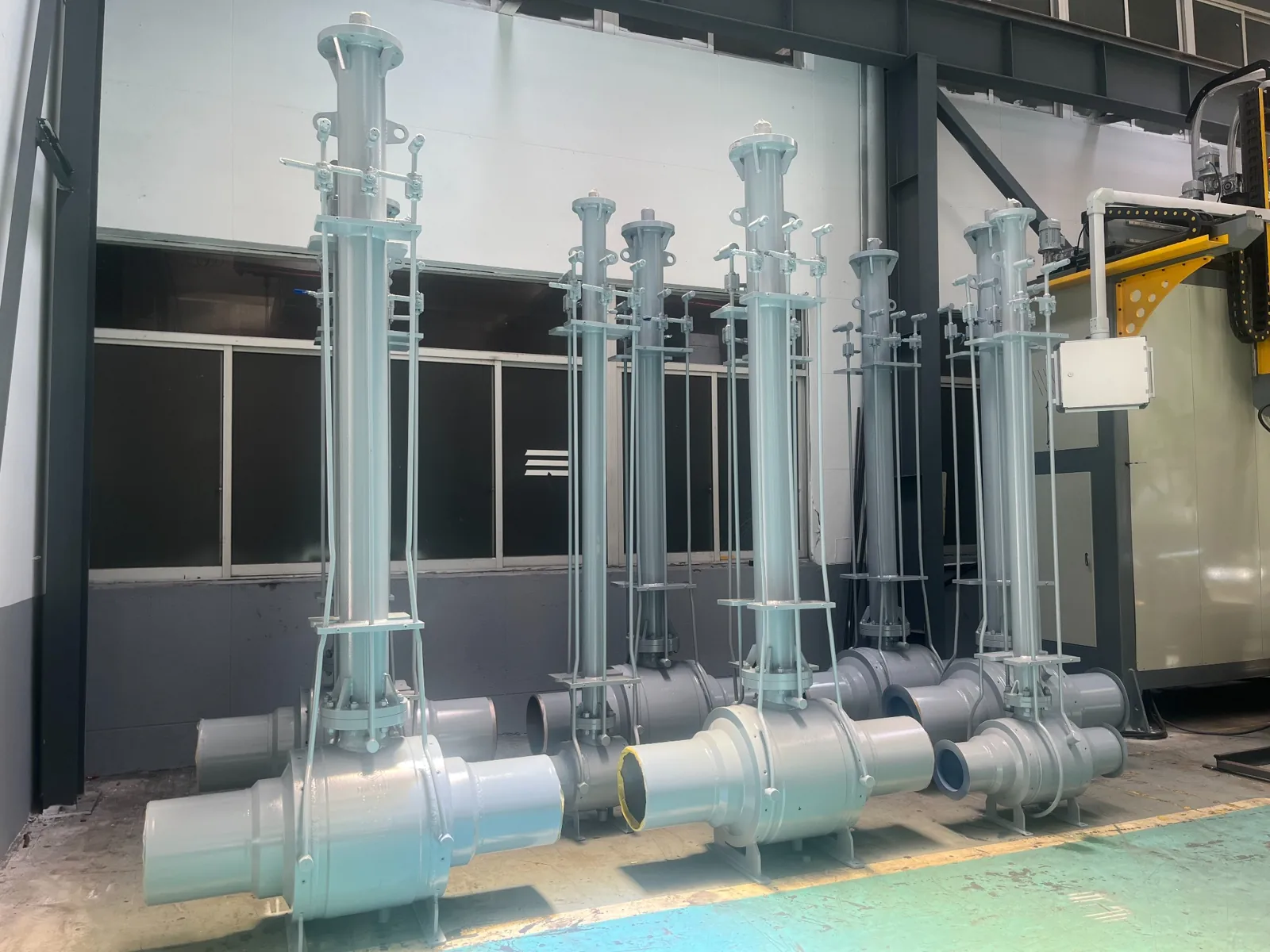 Lineup of large valves with extended stems in the workshop
